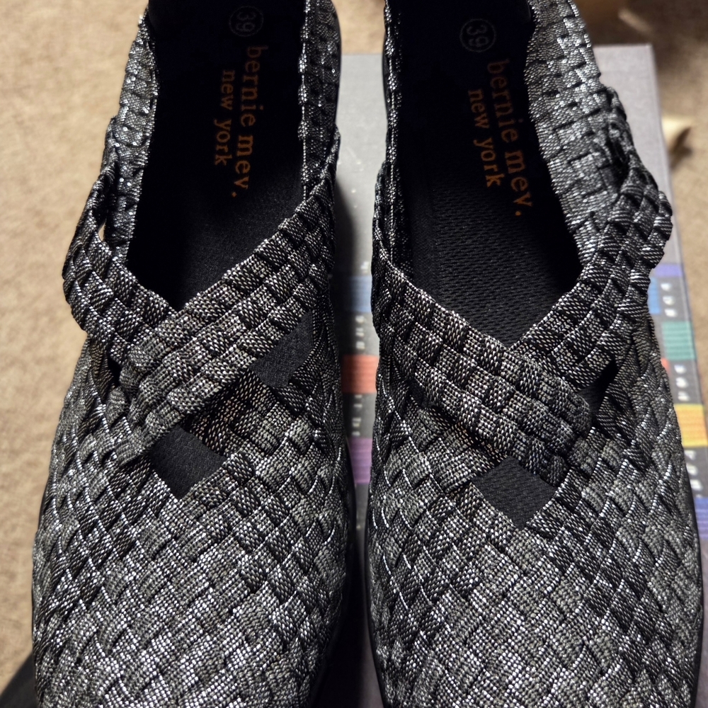 The CLEOPATRA BY Bernie Mev. Metallic Woven Slip-On Flats in Silver and Black
